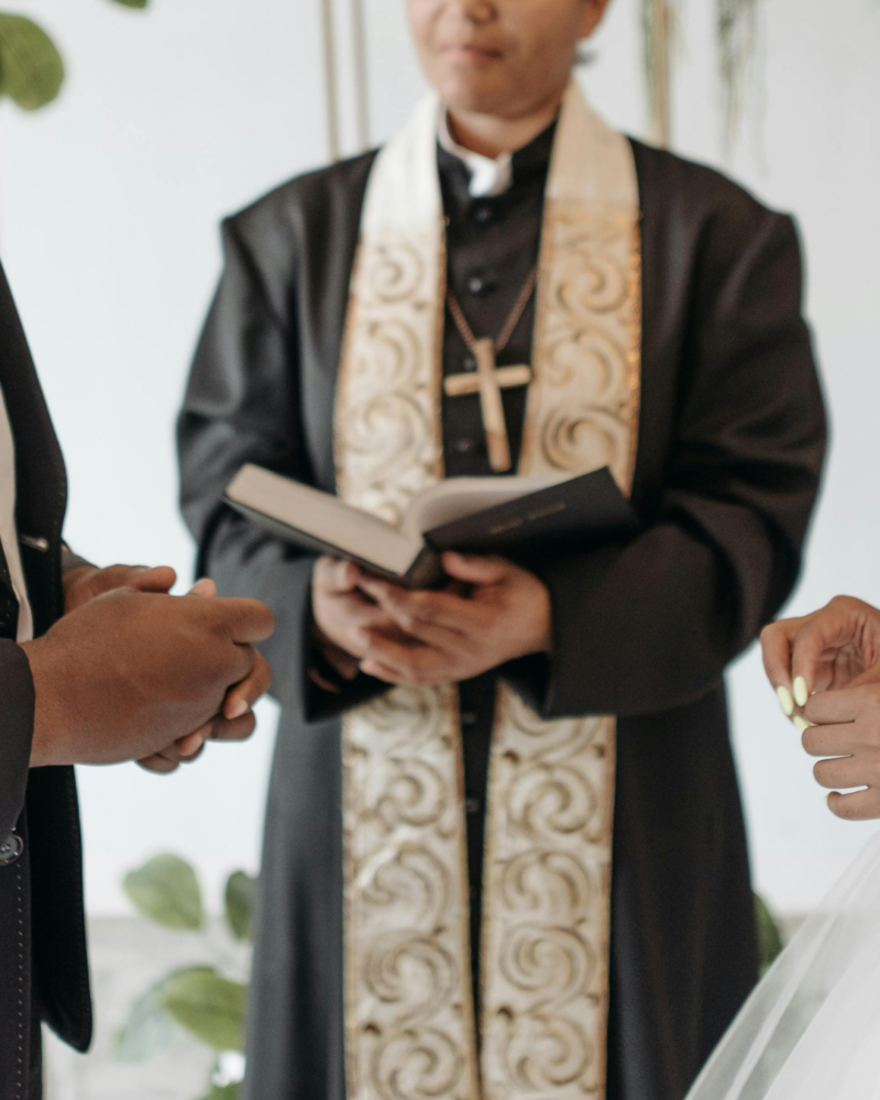 A church elder in Uthiru has resulted to looking for a wife for her son who has refused to settle. Photo: Couple at their wedding ceremony with a priest. Pexel/ Pavel Danilyuk.