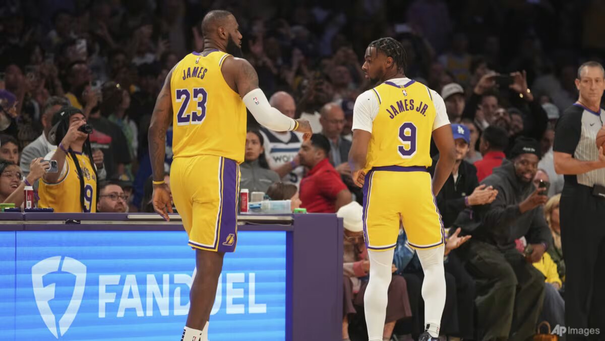 LeBron and Bronny James check into NBA game together, LeBron James with son Bronny during Lakers game, father-son duo NBA debut
