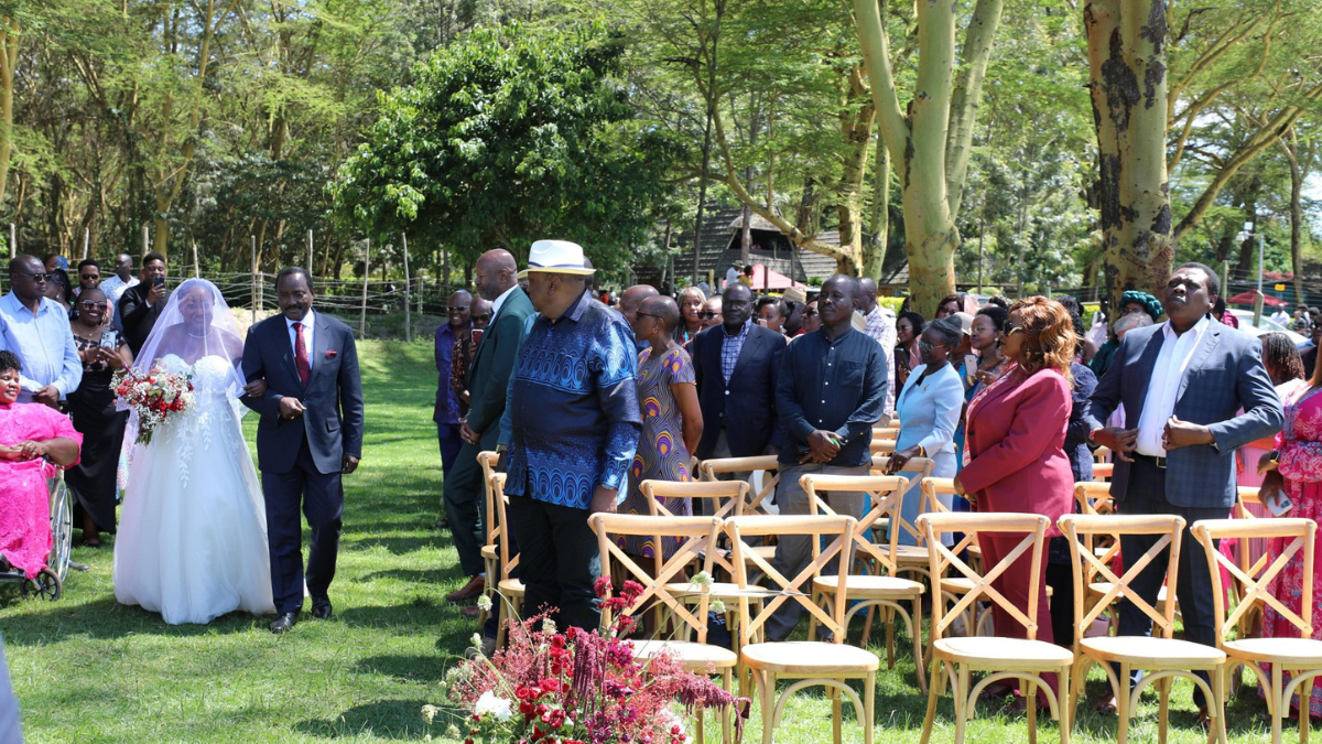 Wiper leader Kalonzo Musyoka and his daughter walk into the wedding venue as guests including former president Uhuru Kenyatta look on.